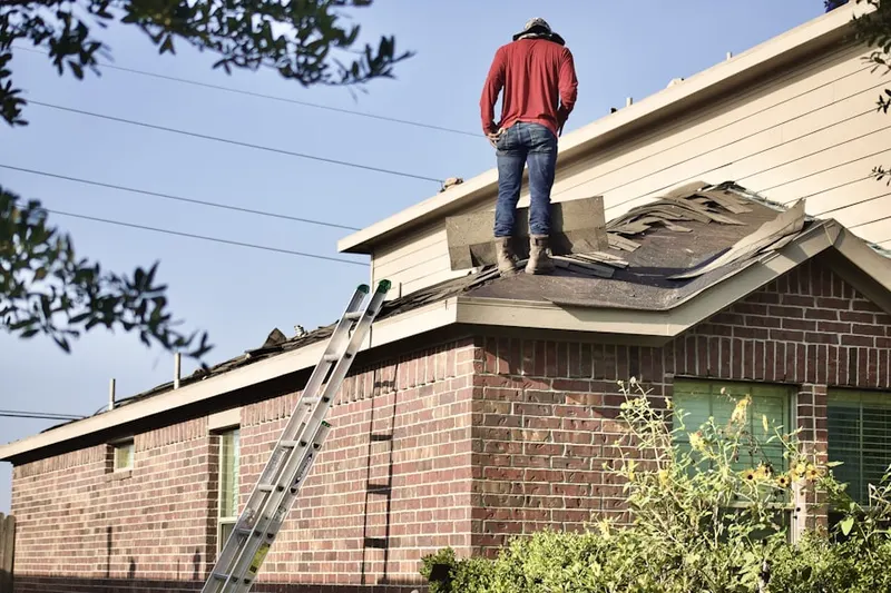 Professional roofer working on a residential roof in Breeden Forest